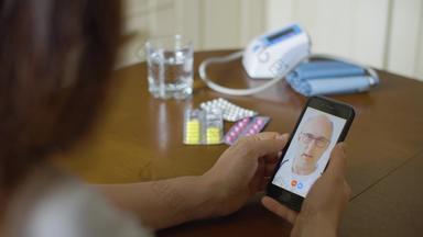 医生医生咨询女人视频调用智能手机屏幕在线医疗咨询远程治疗流感大流行视频谈话医生移动